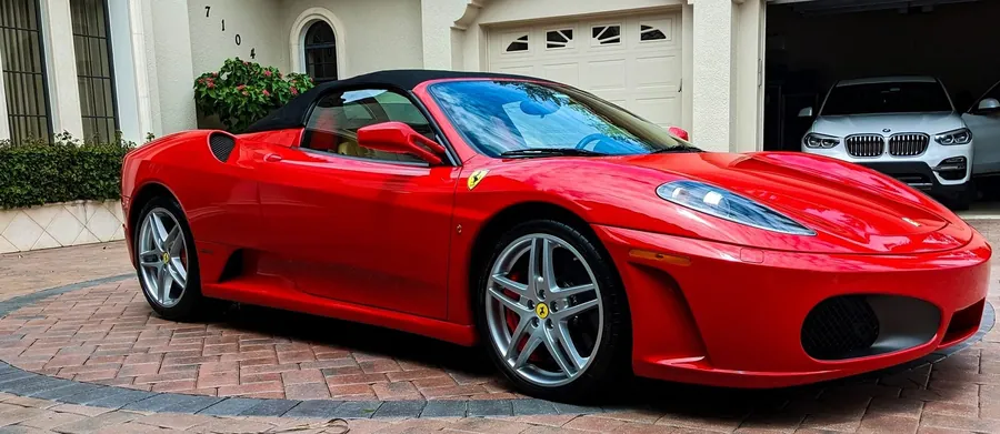 Fully detailed red Ferrari convertible parked in a driveway